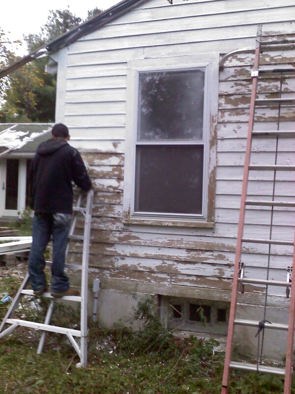 Scraping house before painting 